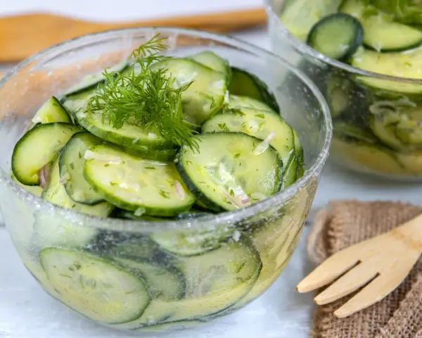 Frischer Gurkensalat mit Dill und Zwiebeln, ein einfaches Gurkensalat Rezept, serviert in einer Glasschüssel.