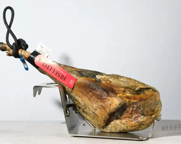 Jamón Joselito en soporte metálico, con etiqueta roja y negra.
