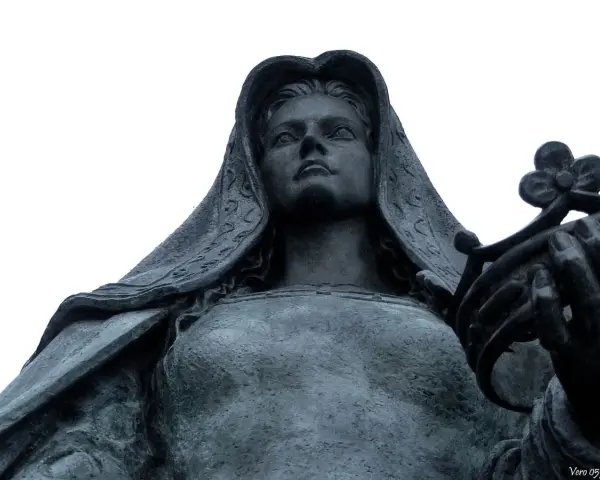 Statue de Jeanne la Folle, voilée, tenant une couronne de fleurs. Son regard est tourné vers le ciel.