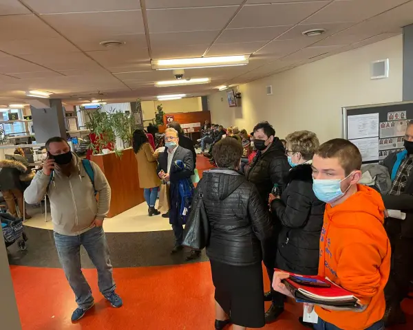 Kolejka ludzi w biurze paszportowym w Częstochowie. Niektórzy mają maseczki.