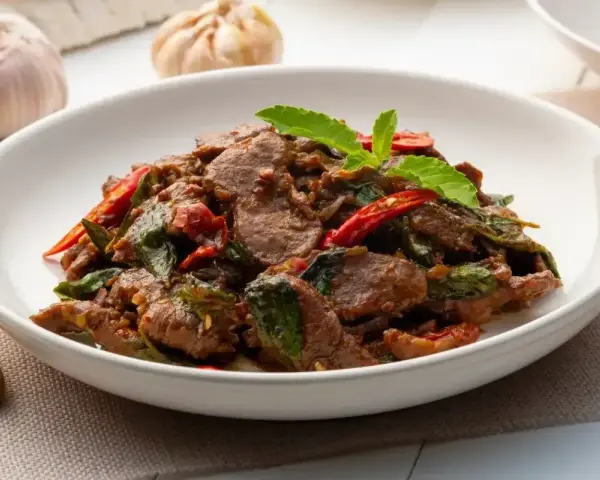 Aksamitne kawałki wołowiny w aromatycznym sosie z bazylią i chili. Pyszne wołowina po tajsku, gotowa do podania.