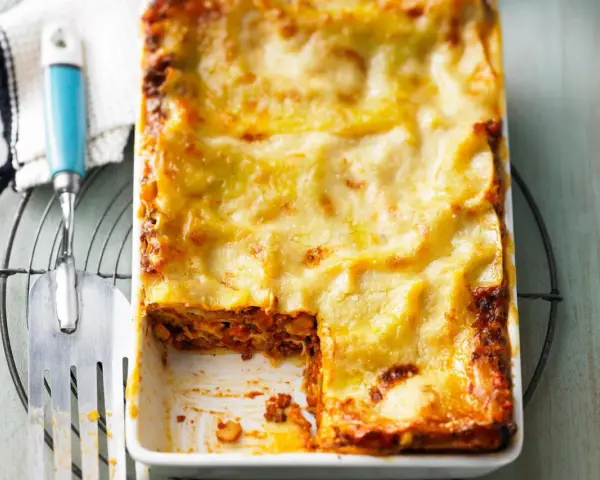 Eine frisch gebackene, goldbraune Lasagne mit geschmolzenem Käse, die Lust auf diese perfekte Lasagne macht.