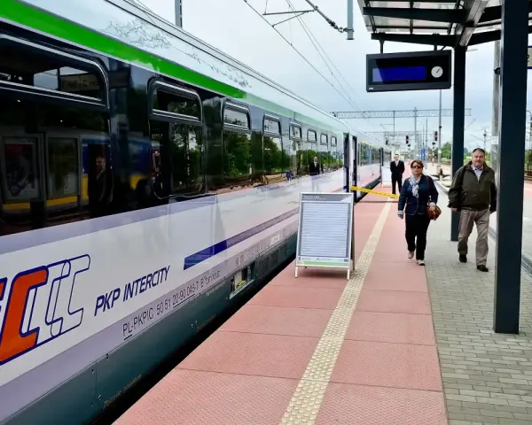 Pociąg Intercity PKP na peronie, ludzie czekają na podróż.