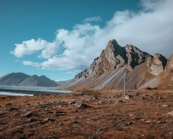 Krajobraz Islandii z górami i jeziorem. Wietrzna reykjavik pogoda z chmurami na niebie.