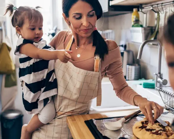 Mutter mit Kleinkind in der Küche, die gemeinsam backen. Tolle Ideen für Rezepte Kleinkinder.