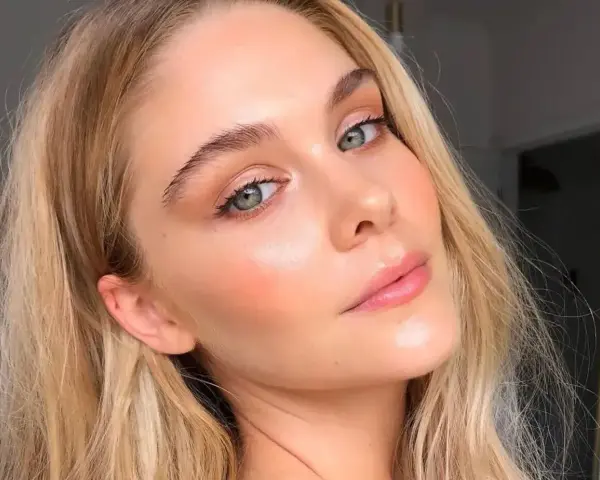 Delikatny makijaż typu "makeup no makeup" podkreśla naturalne piękno kobiety z zielonymi oczami i blond włosami.