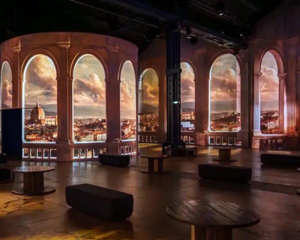 Une projection immersive d'une ville italienne, évoquant la splendeur de la renaissance italienne, avec des arches et un ciel dramatique.