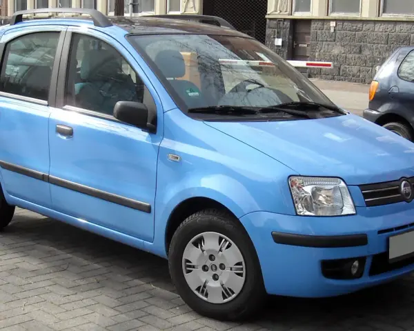 Una Fiat Panda blu parcheggiata su un selciato. Il suo peso è ideale per la città.