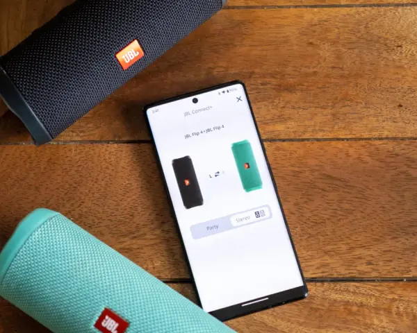 Dwa głośniki JBL Flip 4, czarny i zielony, połączone przez aplikację JBL Connect+ w trybie stereo.