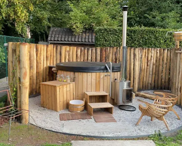 Entspannende gartendusche ideen: Ein Whirlpool mit Holzverkleidung, daneben ein Holzofen und Sitzgelegenheiten aus Holz.