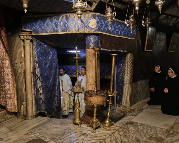 Im Inneren der Geburtsgrotte, wo ist Jesus geboren, stehen Priester und Nonnen in Andacht.