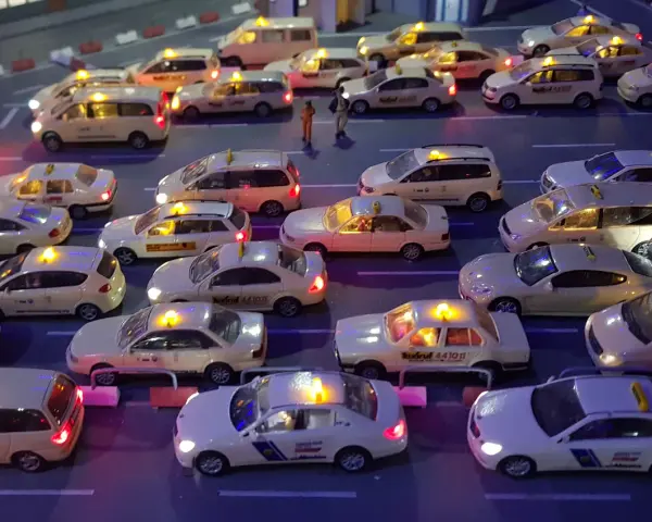 Modellautos von Taxis stehen im Stau. Die Lichter leuchten, als ob sie Nachtzuschlag berechnen würden.