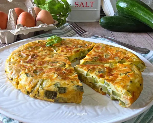 Una gustosa frittata di zucchine, dorata e soffice, con zucchine fresche, uova e basilico. Perfetta per un pasto leggero.