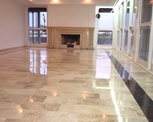 Pavimento in marmo beige con finitura a specchio, che riflette le luci e le finestre. Un lavoro di lucidatura perfetto per un ambiente elegante.