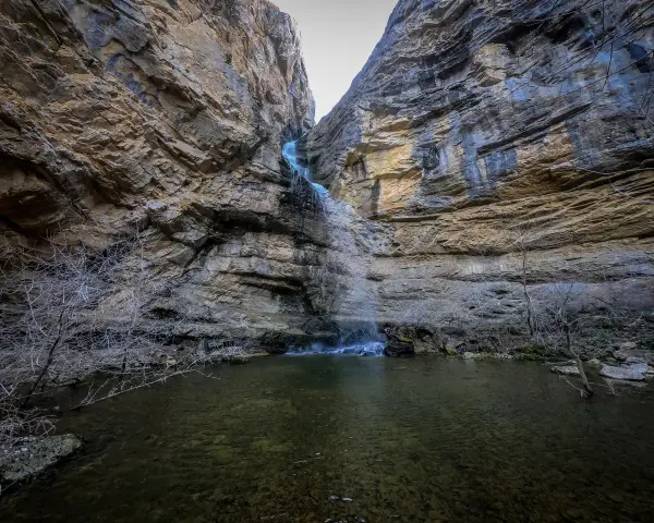 Cascadas en Guadalajara, un estrecho cañón rocoso con una cascada cayendo en una poza de agua clara.
