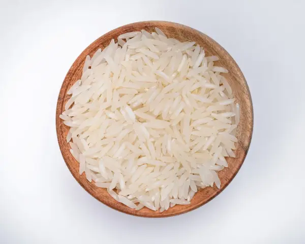 Miseczka z ryżem parboiled na białym tle.