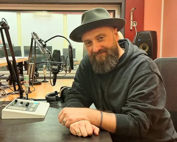 Łukasz Drapała w studio radiowym, gotowy na szalony bal dźwięków.