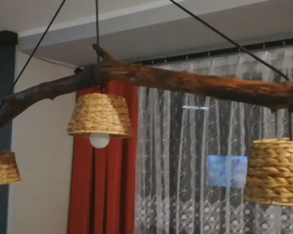 Jak odnowić stary drewniany żyrandol? Ta rustykalna lampa z gałęzi i plecionych kloszy z pewnością doda uroku wnętrzu.