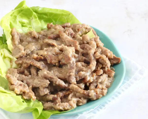 Straccetti di manzo succulenti serviti su foglie di lattuga fresca, un piatto invitante e saporito.