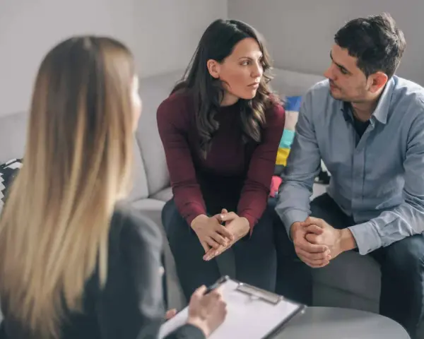 Un couple discute avec un psychiatre lors d'une séance de thérapie de couple.