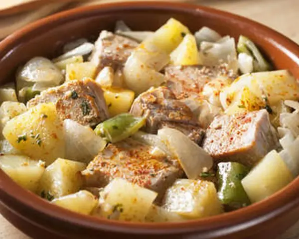 Un delicioso marmitako de atún con patatas, pimientos y cebolla en una cazuela de barro.