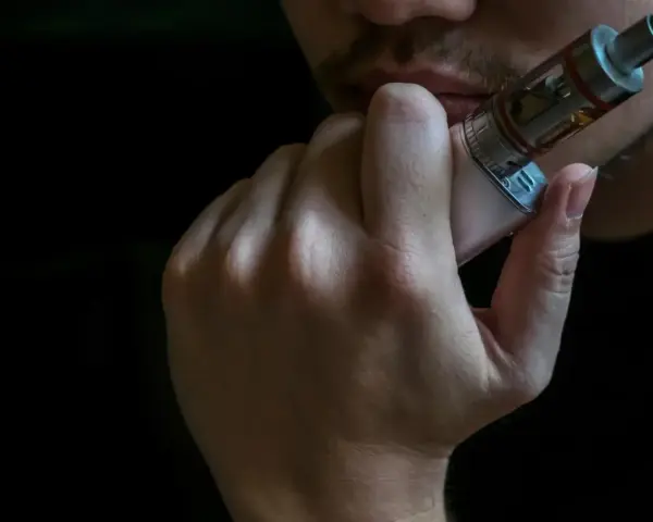 Persona vapeando, disfrutando de los mejores sabores vaper.