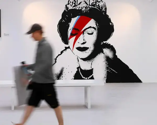W galerii sztuki widzimy słynne dzieła Banksy'ego: portret królowej z błyskawicą na oku, nawiązującą do Davida Bowiego, oraz inne prace.