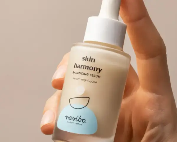 Dłoń trzyma buteleczkę serum Resibo Skin Harmony. Składnik alantoina dba o ukojenie skóry.
