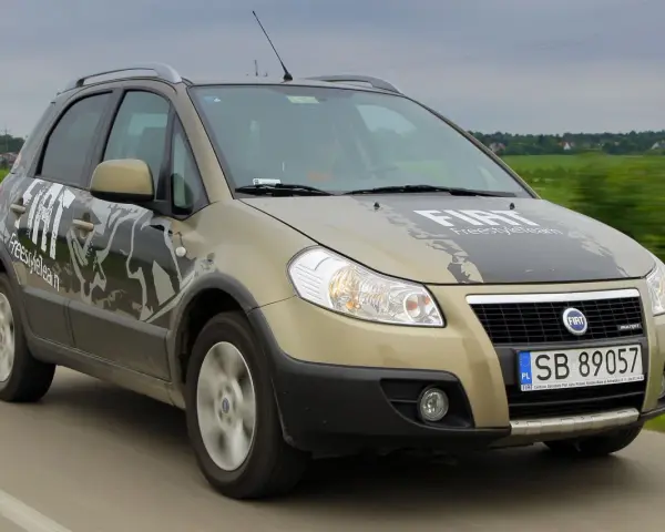 Złoty Fiat Sedici FreestyleTeam w ruchu. Wiele osób szuka opinii o tym modelu.