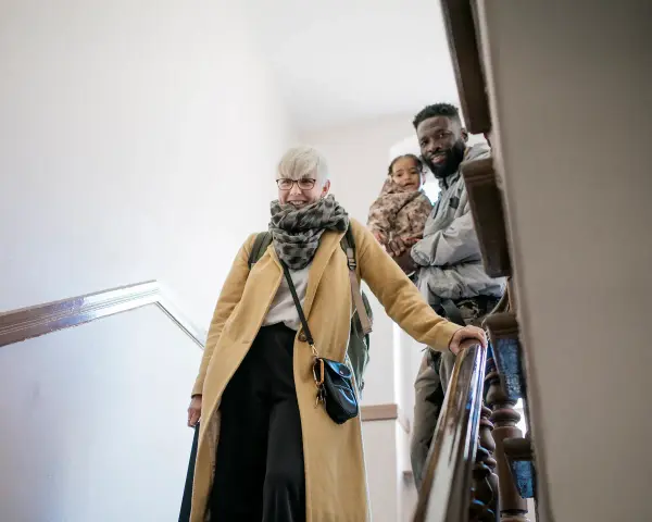 Glückliche Familie auf Treppe, die sich auf den Weg macht. Mit Ehe-Rechtsschutz ohne Wartezeit sind sie für alles gerüstet.