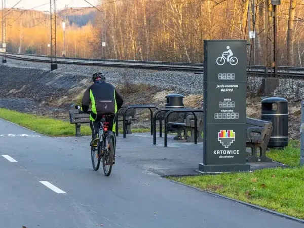 Rowerzyści na ścieżce wzdłuż torów kolejowych. Nowe trasy rowerowe Śląsk zachęcają do aktywnego spędzania czasu.