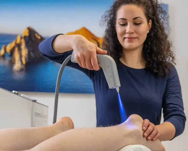 Therapeutin behandelt Fersensporn mit Kälteanwendung. Die Cryo-Therapie lindert Schmerzen, wie bei Liebscher & Bracht empfohlen.