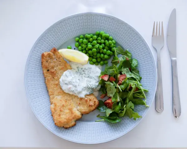 Panerad fisk med ärtor, sallad och en krämig skolans dillsås. En klassisk svensk rätt som smakar sommar.