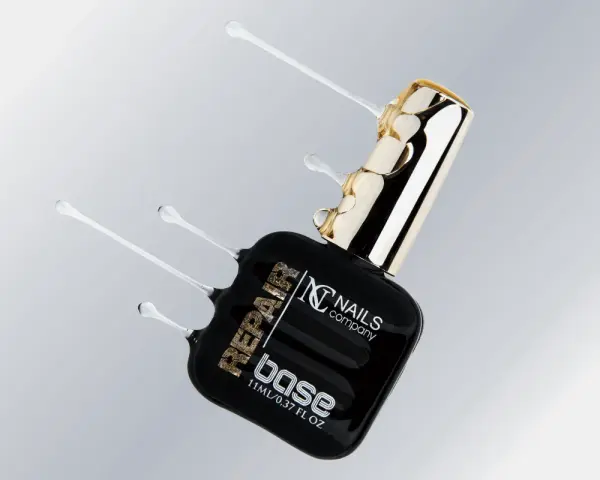 Czarna buteleczka z produktem do paznokci "base" od Nails Company, z płynnym, przezroczystym produktem wypływającym z butelki.
