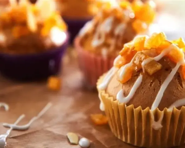 Słodkie muffinki czekoladowe kontra babeczki z nadzieniem, ozdobione lukrem i owocami.