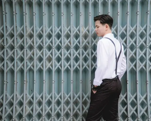 Elegancki mężczyzna w białej koszuli i szelkach, gotowy na white party.