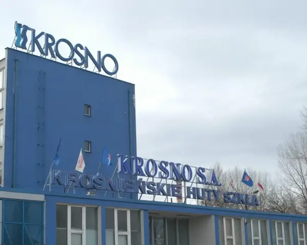 Niebieski budynek z napisem "KROSNO S.A. KROŚNIEŃSKIE HUTY SZKŁA".