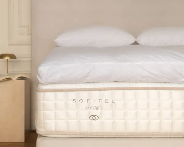 Un matelas Sofitel My Bed, symbole d'un choix literie de luxe, avec des draps blancs et des oreillers moelleux.