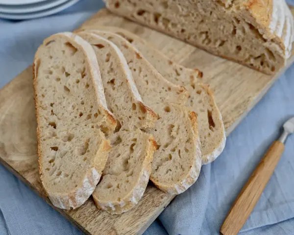 Aufgeschnittenes italienisches Brot mit Lievito Madre auf einem Holzbrett, bereit zum Genießen.