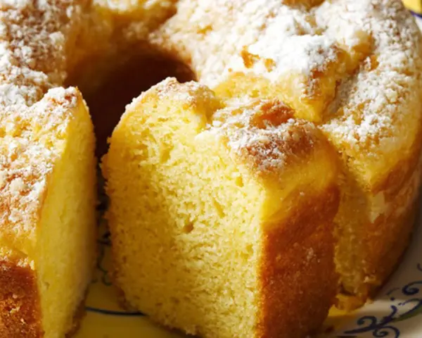 Un soffice ciambellone allo yogurt, cosparso di zucchero a velo, pronto per essere gustato.
