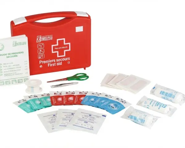Trousse pharmacie bébé 2 ans : une trousse rouge de premiers secours avec pansements, compresses, ciseaux, pince à épiler et guide.