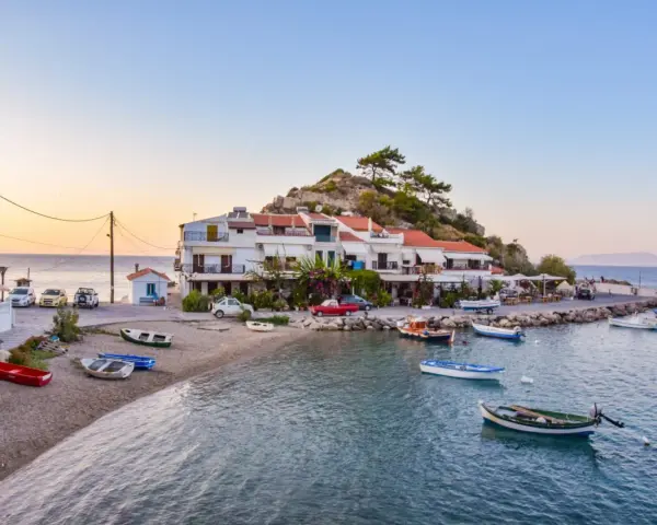 Widok na zatokę Vathy na Samos z łodziami i budynkami na tle wzgórza.