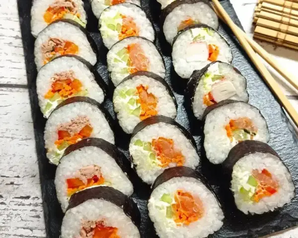 Gotowe rolki sushi z łososiem, tuńczykiem i warzywami. Prosty sposób, jak zrobić sushi w domu.