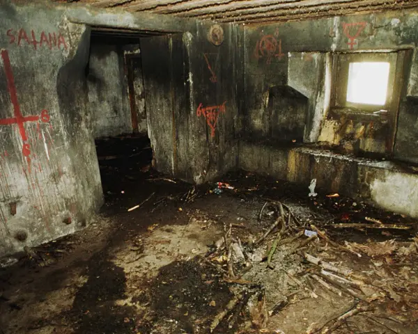 Wnętrze bunkra 44, ściany pokryte graffiti, na podłodze gruz i gałęzie.