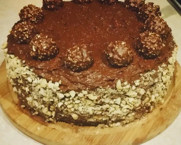 Czekoladowy tort udekorowany chrupiącymi orzechami i pysznymi pralinami Ferrero Rocher.