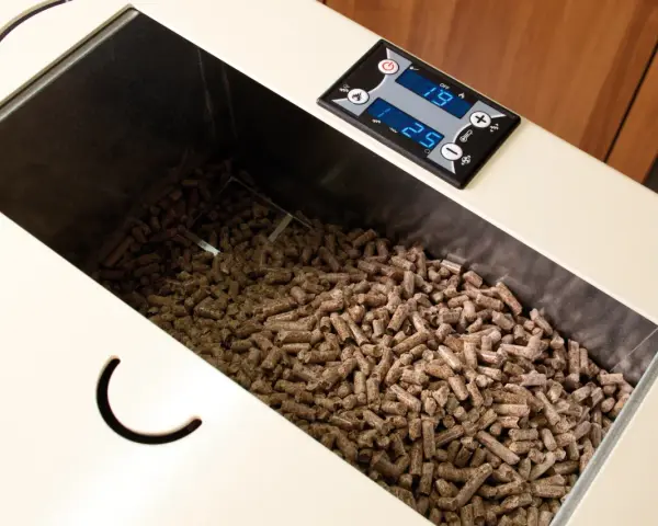 Serbatoio pieno di pellet, alcuni sembrano un po' troppo lunghi per la stufa. Il display digitale mostra 19 e 25.