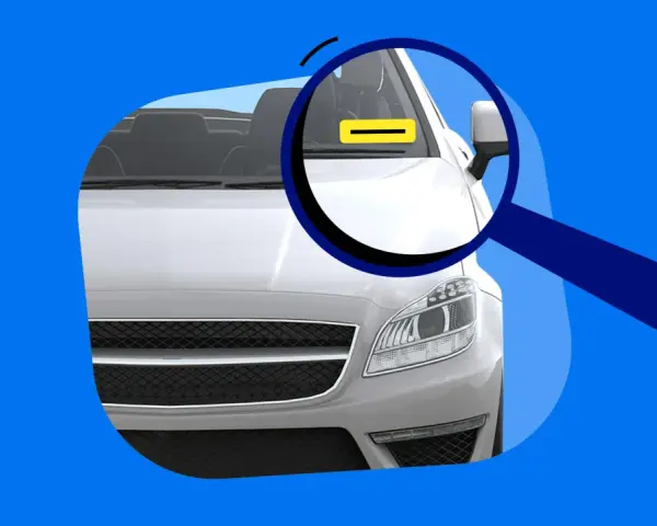 Lupe über dem Auto, die auf eine gelbe Markierung am Armaturenbrett zeigt. Das erklärt, was bedeutet FIN beim Auto.