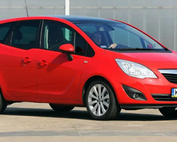 Czerwona Opel Meriva z czarnym dachem, idealna do miasta. Jaki silnik benzynowy wybrać? Ten model oferuje komfort i praktyczność.