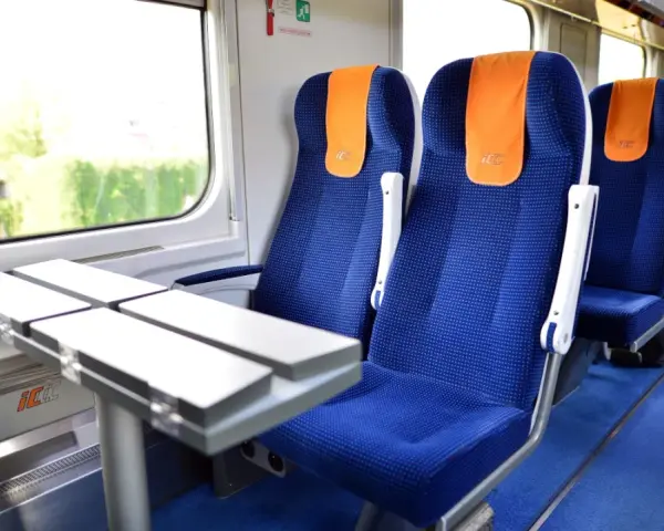 Wygodne siedzenia w pociągu PKP Intercity, gotowe na podróż do Warszawy.