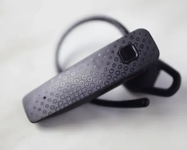 Czarna słuchawka Bluetooth z wytłoczonym wzorem kółek. Dowiedz się, jak sparować ją z telefonem.